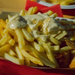 Currywurst mit Sauce und Pommes frites in der Schale