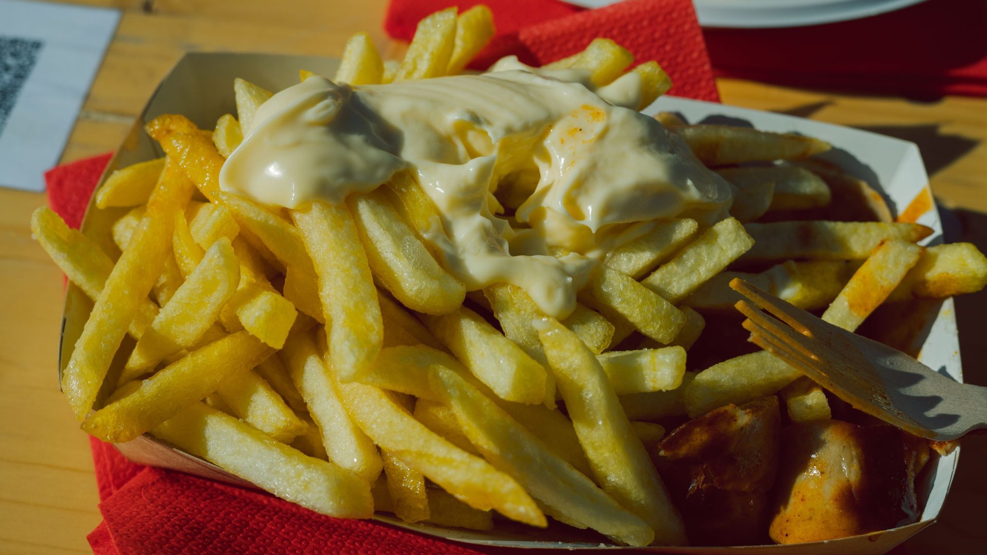 Currywurst mit Sauce und Pommes frites in der Schale