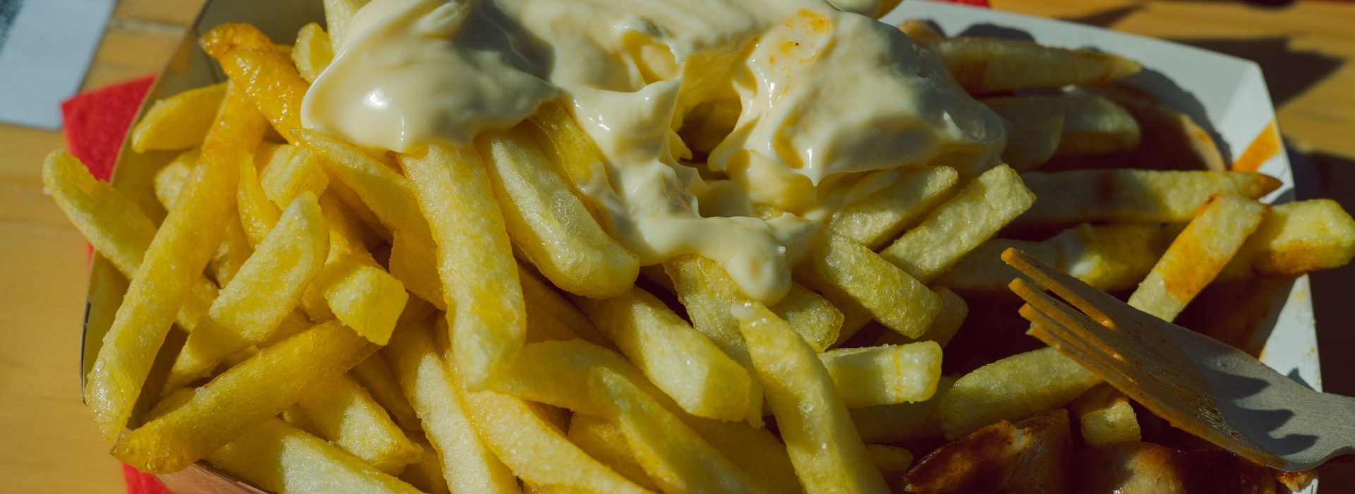 Currywurst mit Sauce und Pommes frites in der Schale