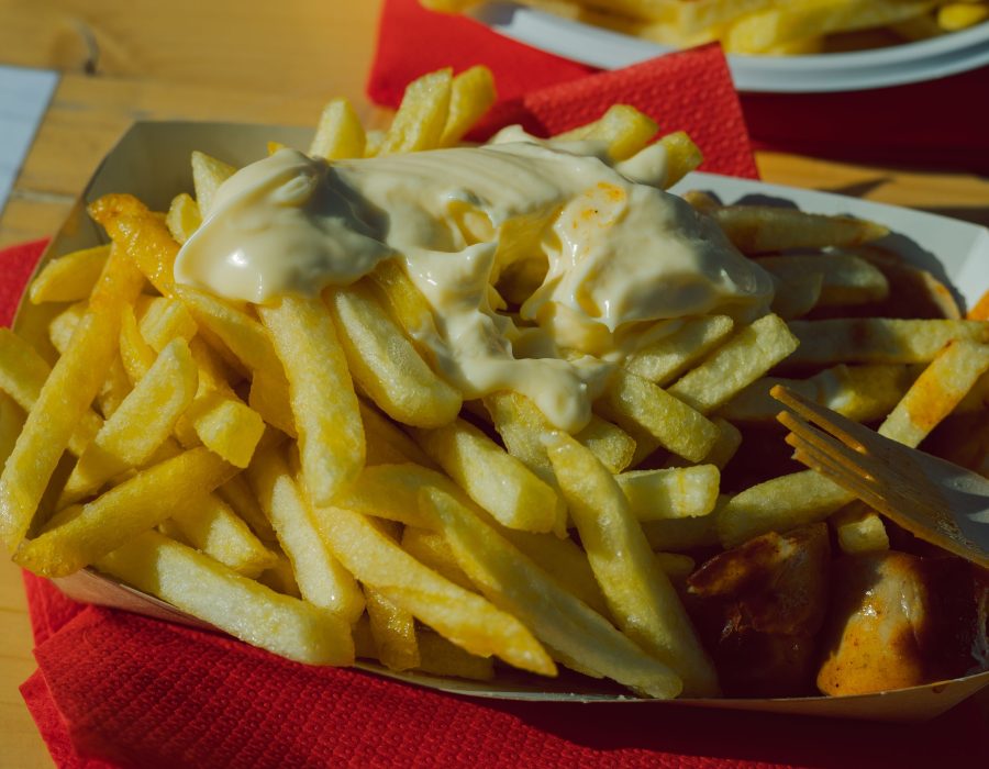 Currywurst mit Sauce und Pommes frites in der Schale